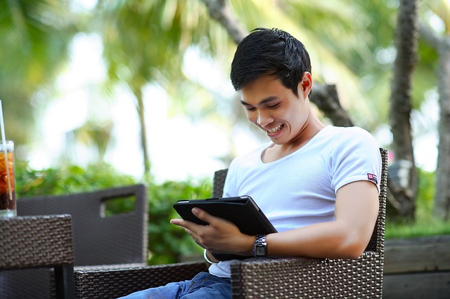 young man sitting outside using tablet