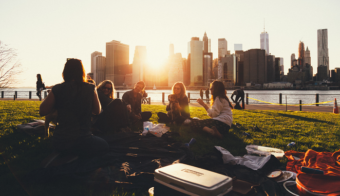 group-of-friends-sitting-in-park-at-sunset