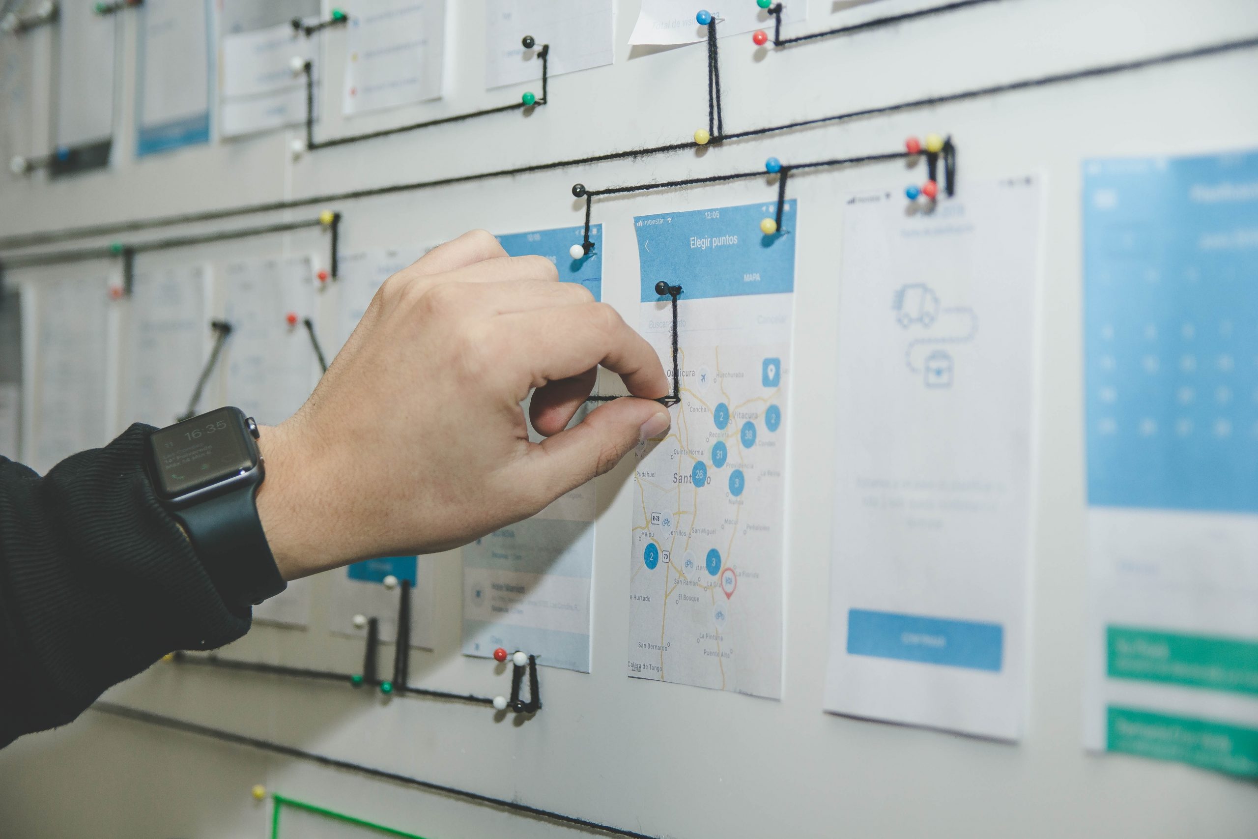 Person pinning notes on a strategy board, project planning.