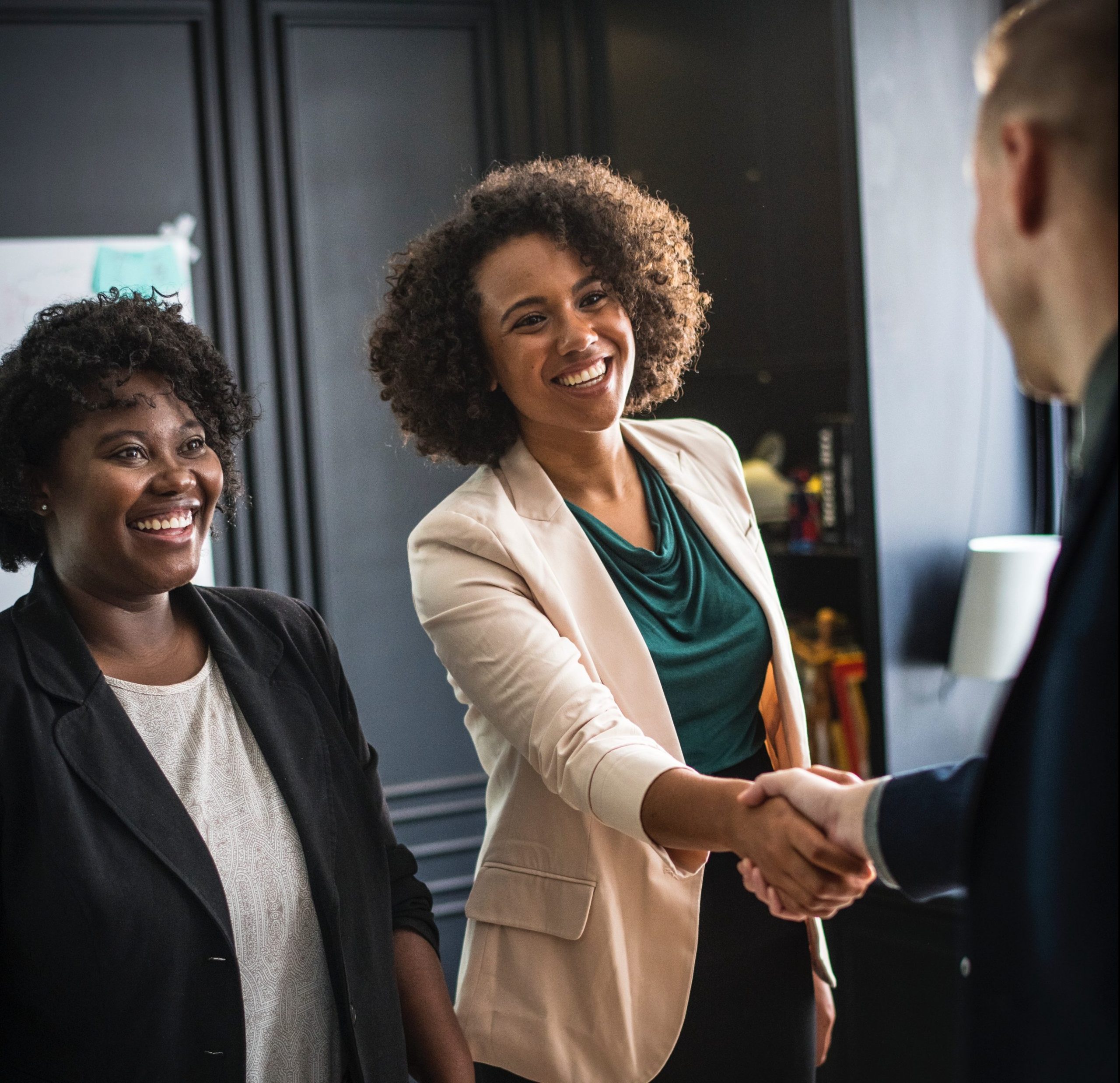 Happy business team during a welcoming handshake in the office.