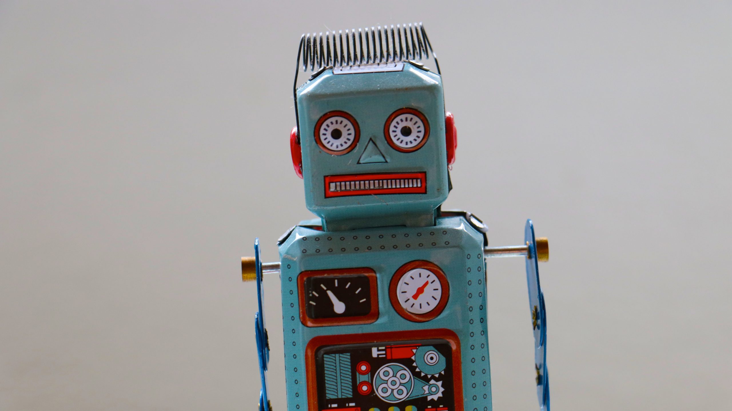 Vintage tin robot toy facing forward on a plain background.