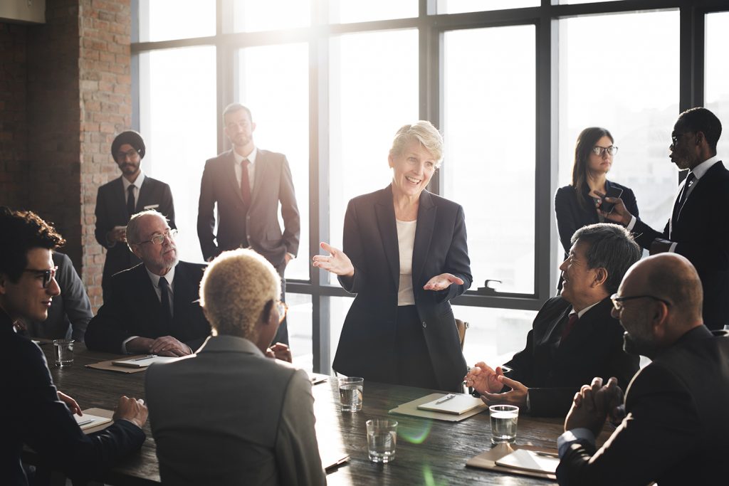 Diverse business professionals engaged in a meeting with a female leader presenting.