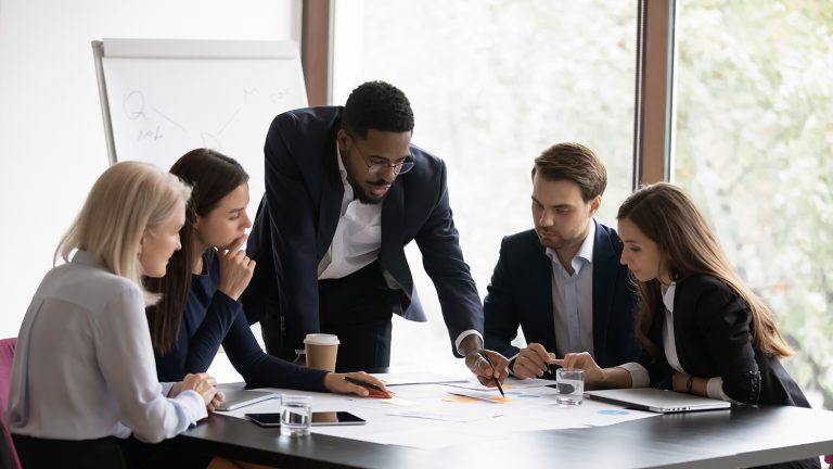 Diverse team of professionals collaborating on a project with documents in an office.