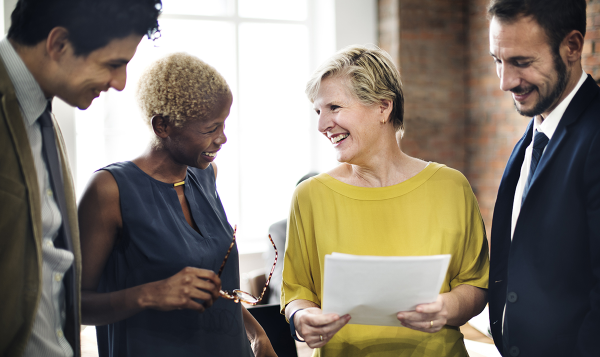 Diverse team smiling during a collaborative office meeting.