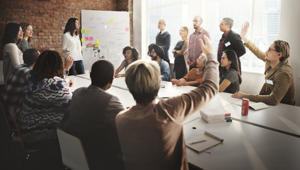 Employee raising hand in a diverse interactive training session.