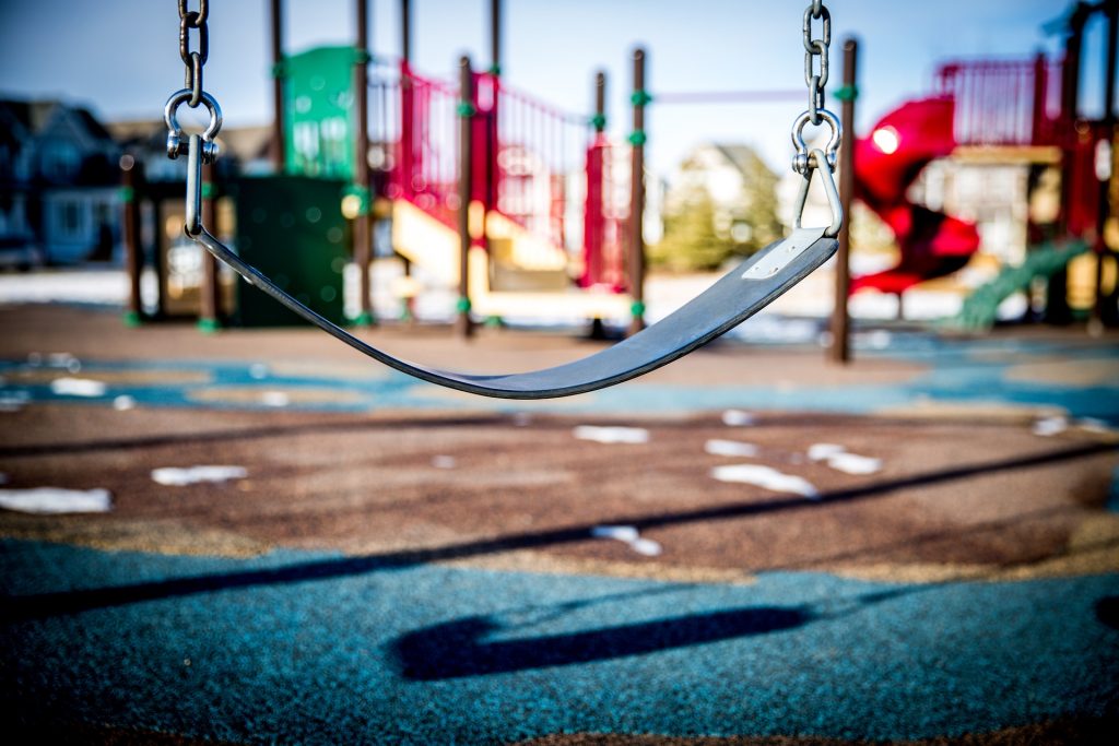 Empty swing in a playground, symbolizing child safety and protection awareness.