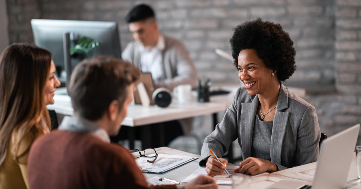 Smiling businesswoman discussing with colleagues in a meeting.