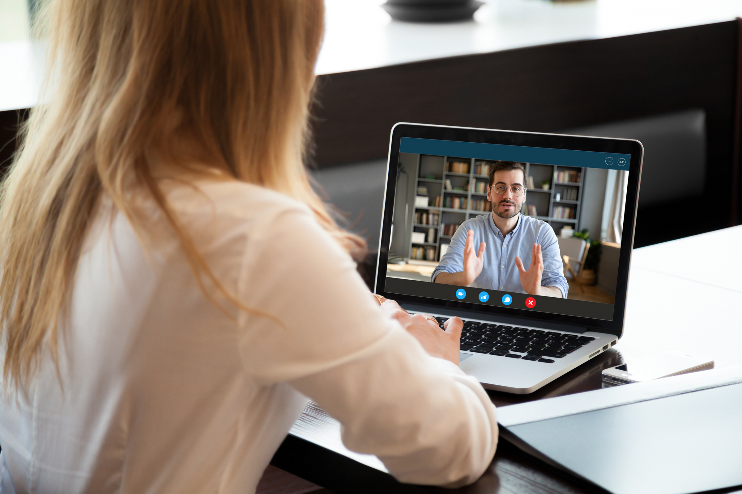 Professional on a video call with a colleague, discussing work remotely.