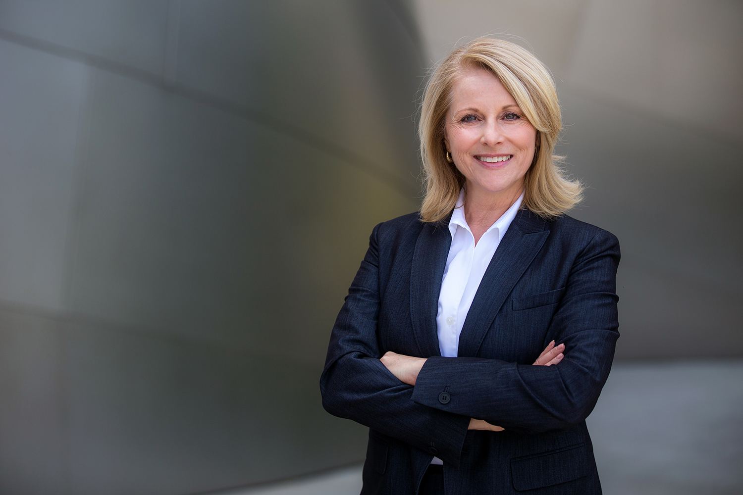 Confident businesswoman with arms crossed smiling.