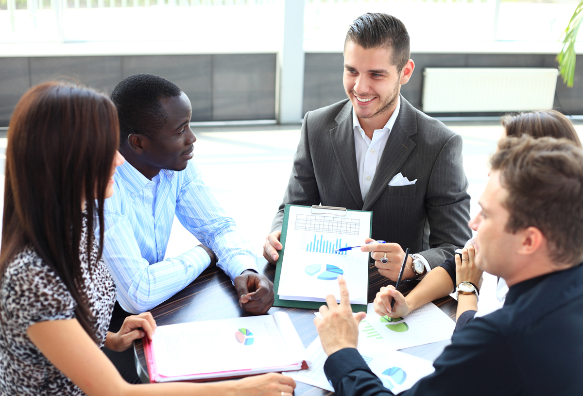 Team of professionals engaged in a discussion with charts and data.