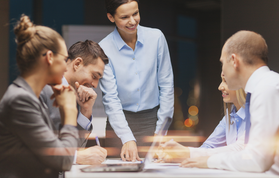 Smiling business team collaborating on a project around a table in a modern office.