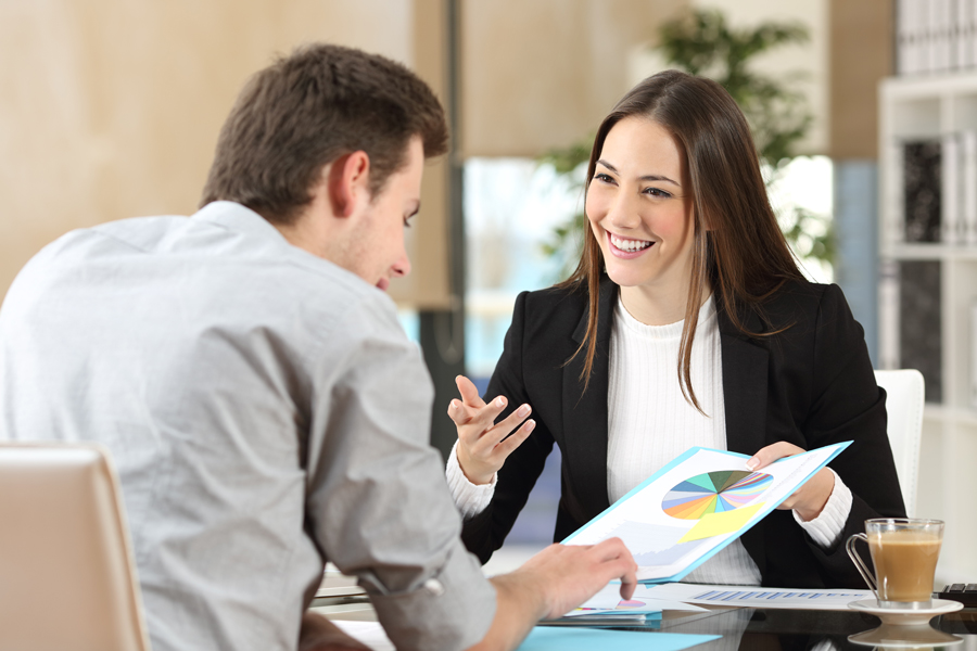 Businesswoman discussing pie chart with colleague during a meeting.