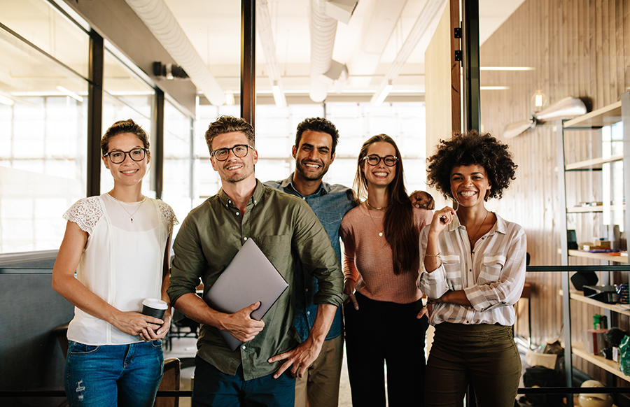 Group of cheerful colleagues in a bright modern office space.