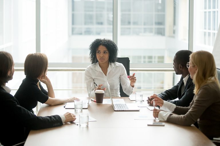 Female leader conducting a meeting with diverse business team.