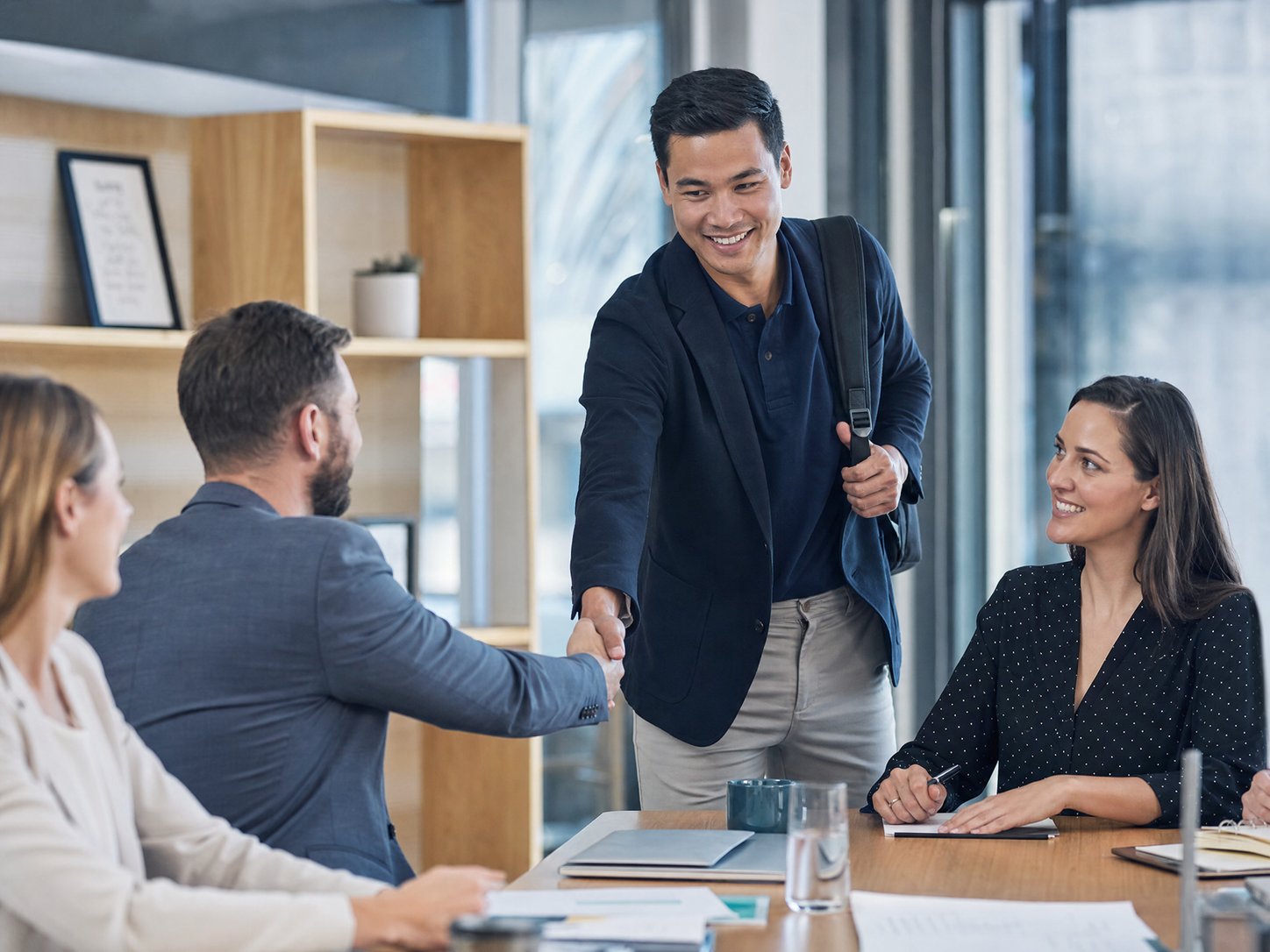 A team welcoming a new colleague at a meeting table