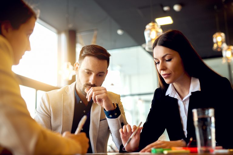 Focused business professionals collaborating and discussing ideas at a table.