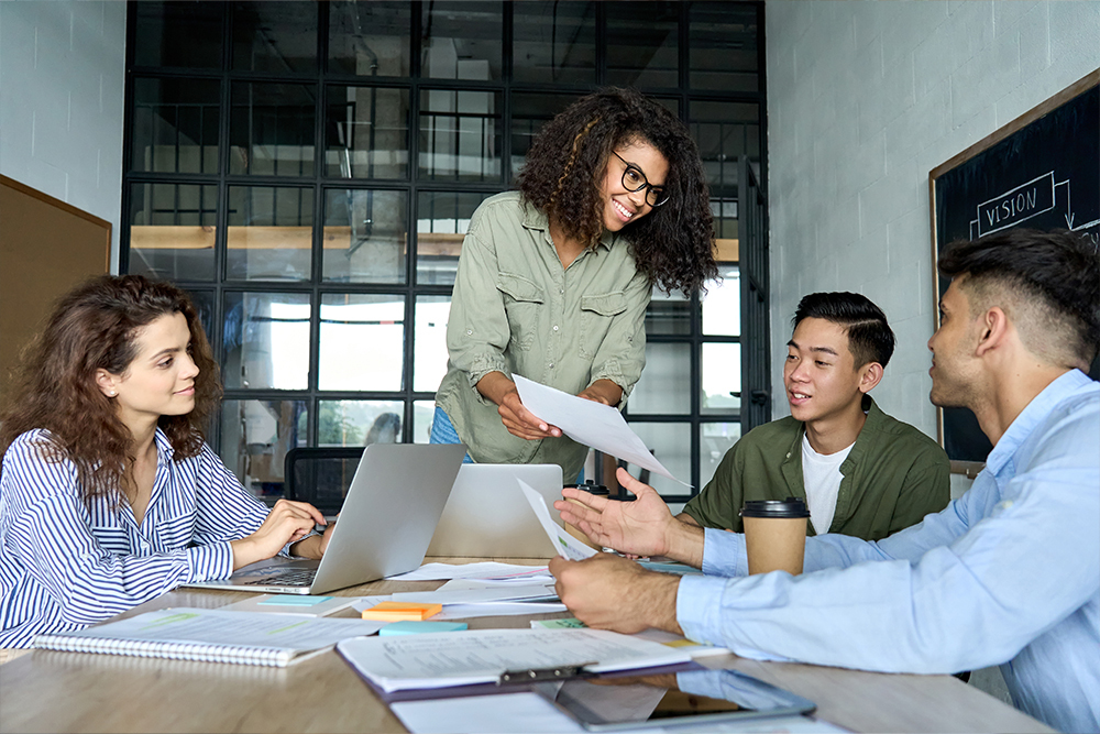 Diverse team discussing project around a table in a modern office.